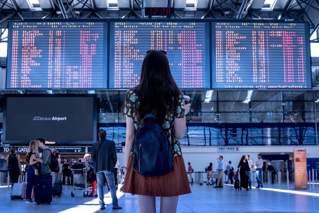 Canadians travelling internationally, pictured looking at flight screens